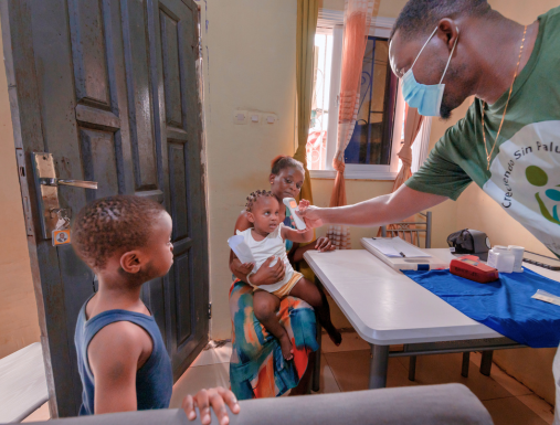 A man takes the temperature of a small child in Equatorial Guinea.