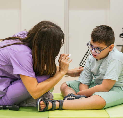 Health care worker interacting with a chidlren with disabilities on the floor