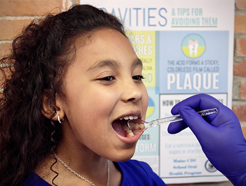 Child having his teeth examined by a registered dental hygienist in a chair