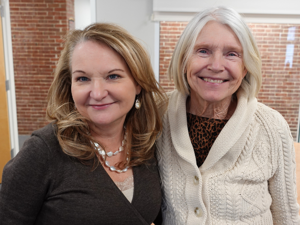 Two women smiling at camera.