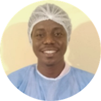 Man smiling at camera while wearing a hair cover and lab coat