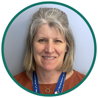 A woman nurse smiling at the camera.