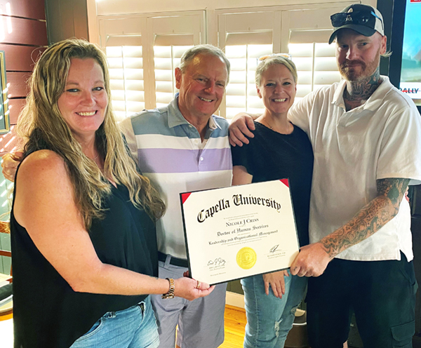 Nicole with family celebrating her graduation