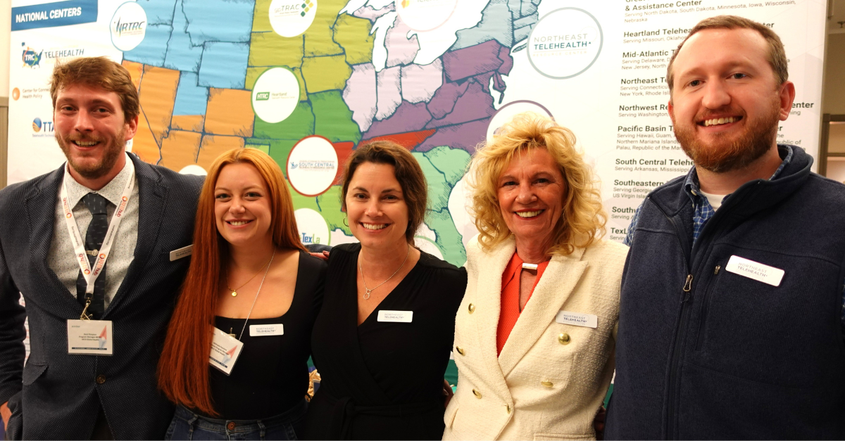 Five people standing with two men and three women in front of a U.S. map smiling at the camera.
