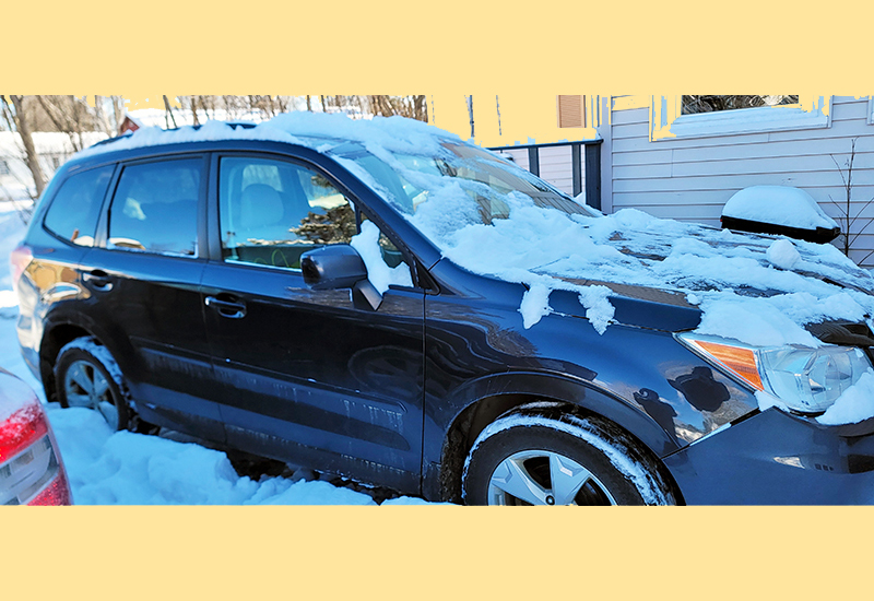 Reid's blue Subaru car covered in snow that he uses to delivery the telehealth equipment to PNMI sites across Maine.