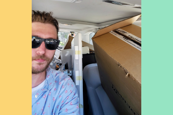 Reid Plimpton taking a selfie of himself in his car packed with boxes for delivery to PNMIs across Maine.