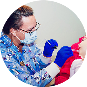 Sherry inspecting child's mouth as part of oral health efforts