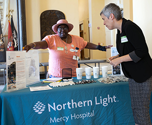 Solange Tchatat working the Northern Light Mercy Hospital booth at an event.