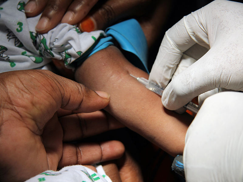 Child receiving vaccination in arm.