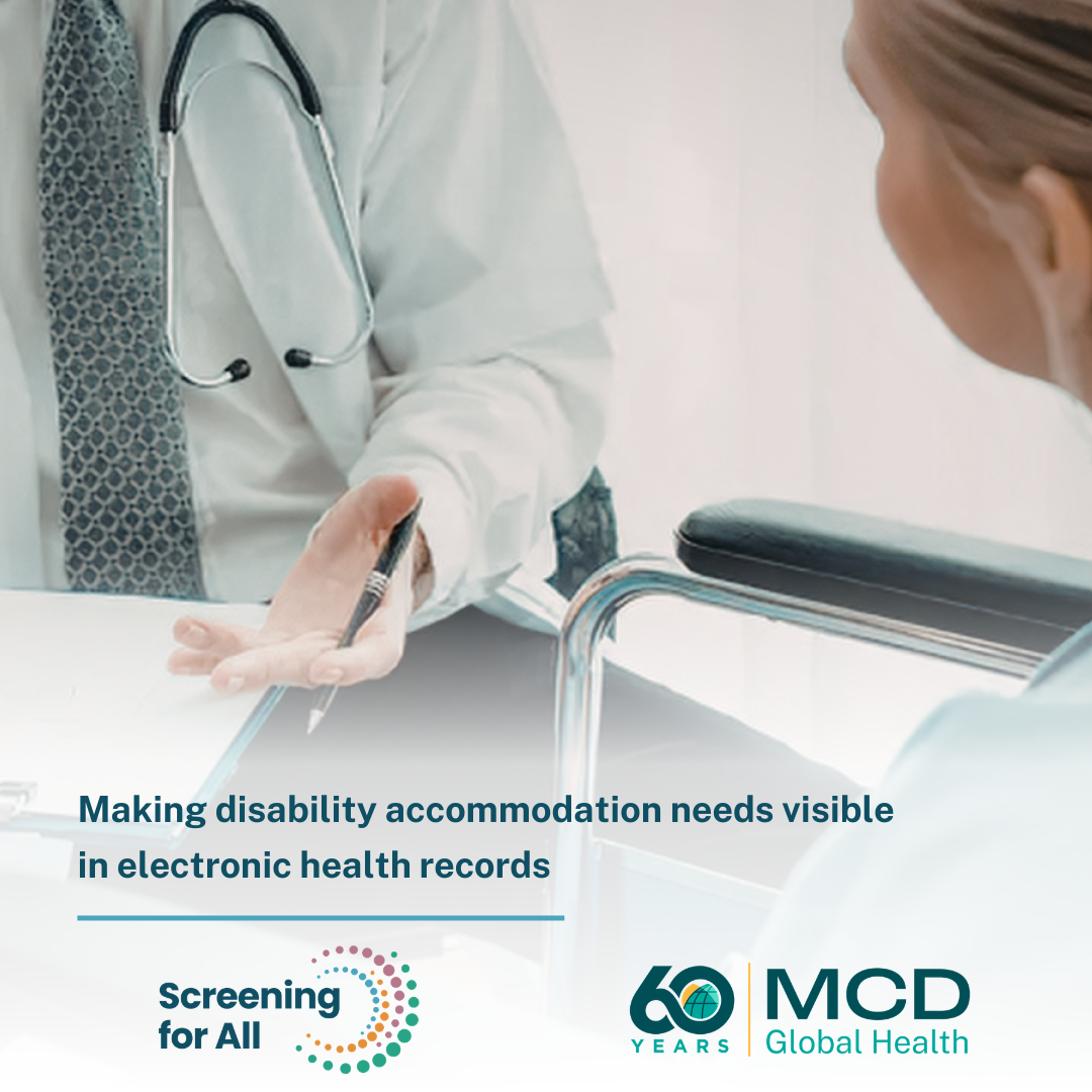 Photo of a provider in a white coat talking with a woman sitting in a wheelchair while going over a clipboard.
