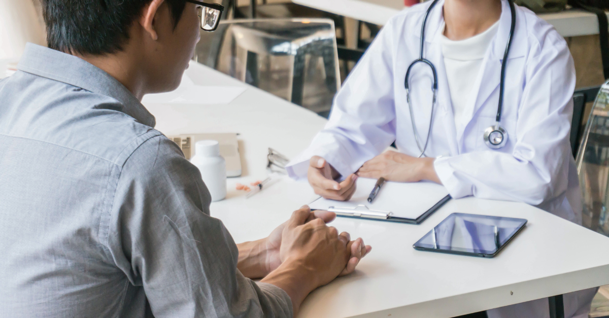 Photo of two people sitting at a table going over a clipboard.